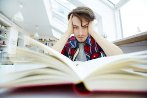 Jovem estudante sentindo a pressão da procrastinação no ENEM.